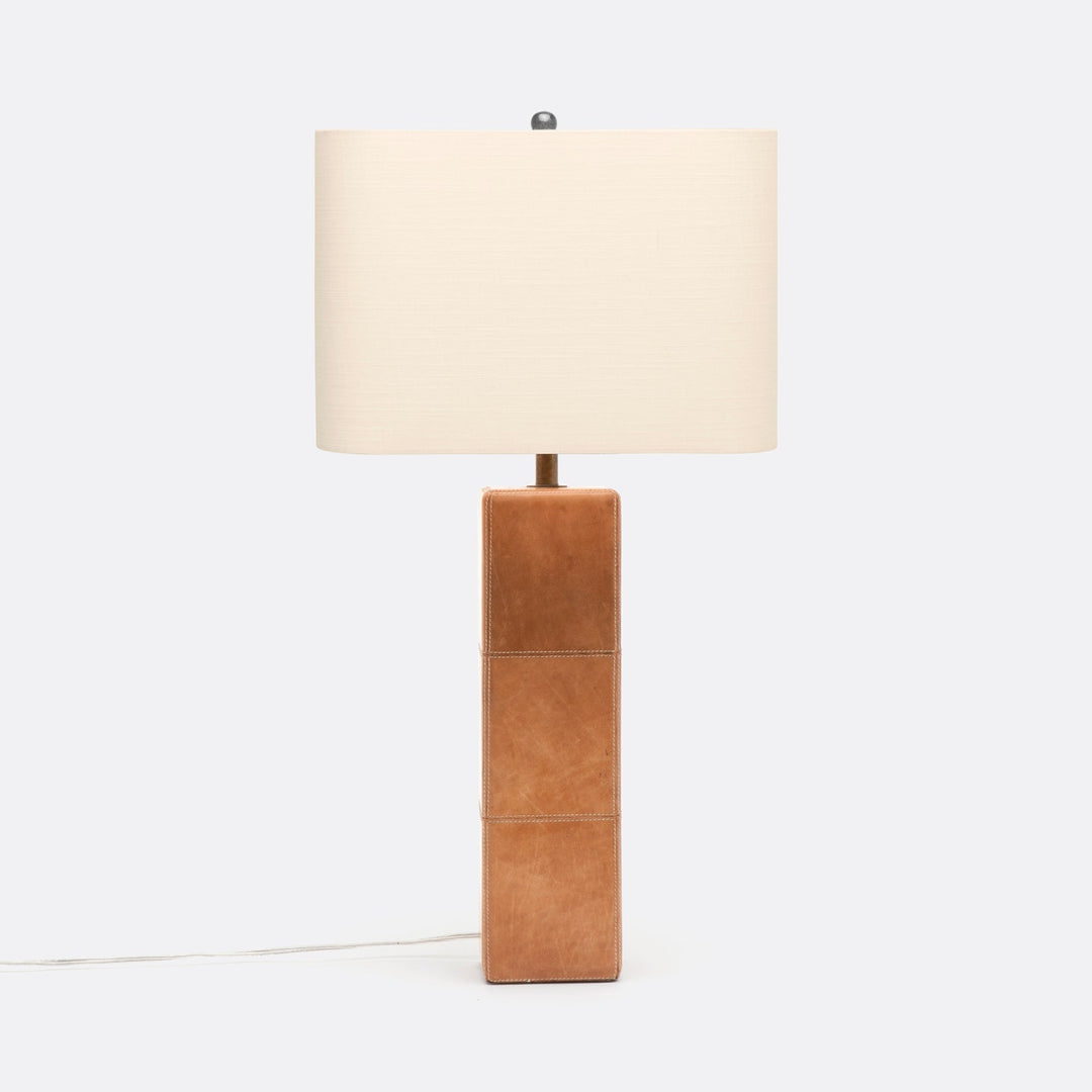 A table lamp with a tan leather wrapped column and a white rectangular lampshade.