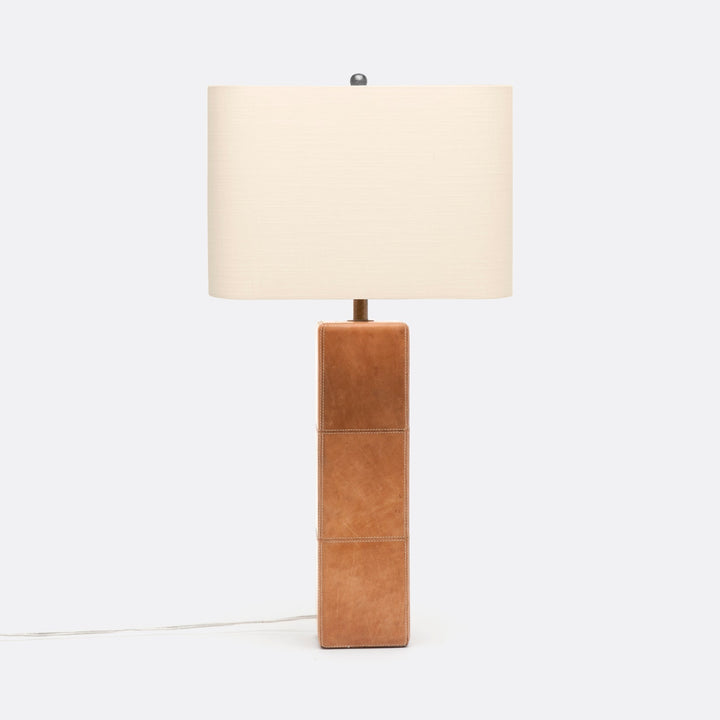 A table lamp with a tan leather wrapped column and a white rectangular lampshade.