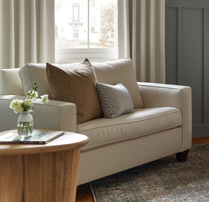 Beige sofa with decorative pillows in a living room setting